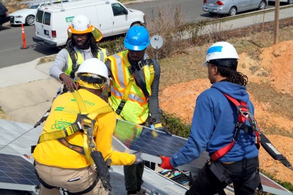 Solar Works DC trainees carry a solar module