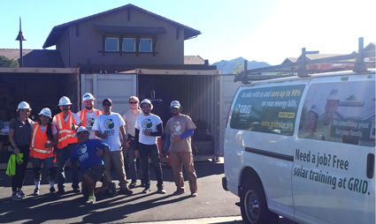 Group of construction workers and trainees standing near a van advertising free job training at GRID