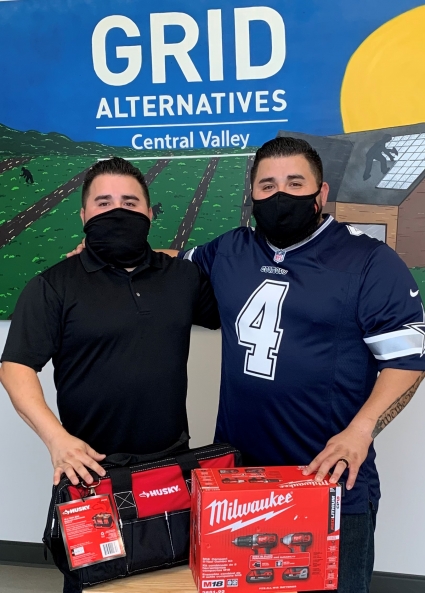 Mario and Jesus Venegas, embracing, show off the tools they earned