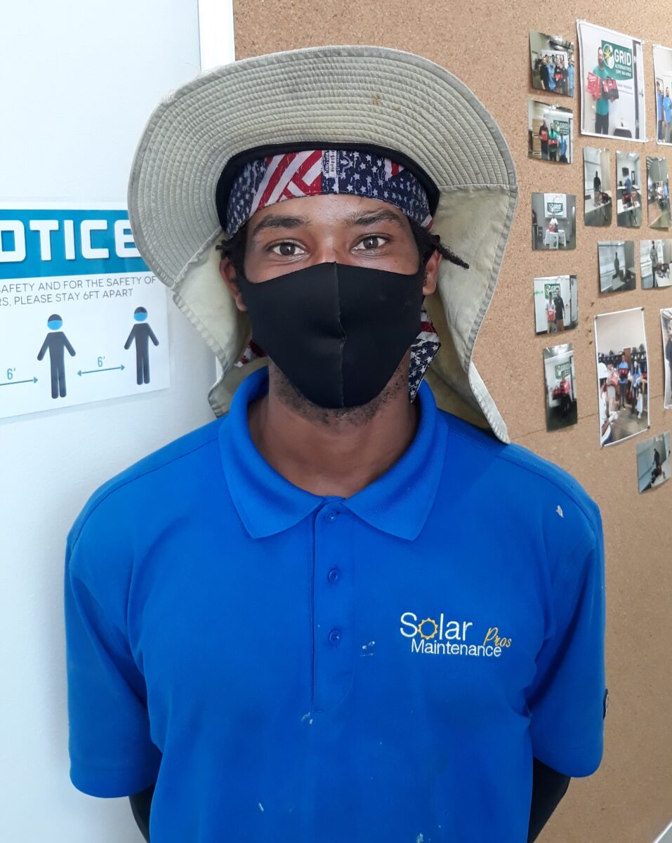 Worker wearing blue Solar Maintenance polo shirt and patriotic headband with wide-brimmed hat indoors