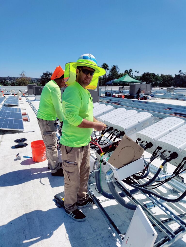 Man in a hard hat and bright green shirt on a roof construction site