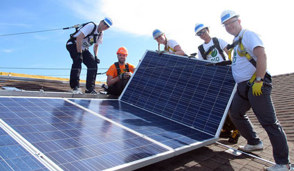 Northland Controls volunteers install a solar module on the roof.