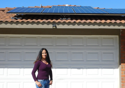 Woman standing in front of house with solar panels on roof