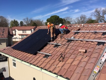 Community members install rooftop solar on the Rolling Hills apartment complex.