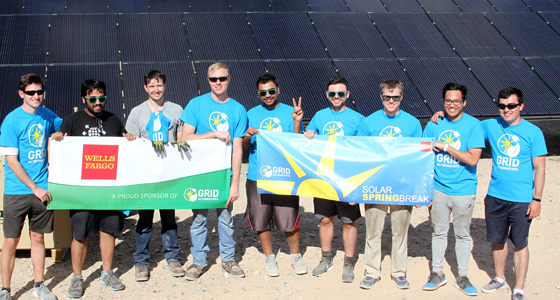Group of students in matching blue shirts holding solar energy banners at ASU Solar Decathlon 2019 event