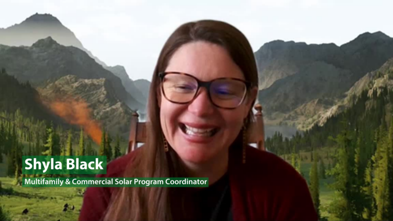 Shyla Black, multifamily & commercial solar program coordinator, smiling at camera with mountain landscape background