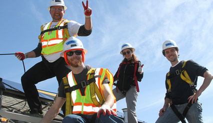 Four SunPower employee volunteers pose on the roof as they're installing solar.