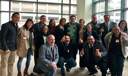 Group of diverse professionals posing together at TCC Coalition event in modern office space