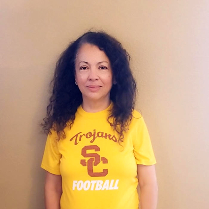 Woman wearing yellow USC Trojans football t-shirt against neutral background