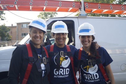 Three We Build volunteers pose by a truck