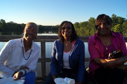 Two potential clients and one current GRID client sit by the river.