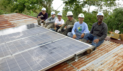 Trojan employees installing a solar panel on the roof of the Nepalese community center.