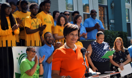 Community event with diverse group wearing yellow and blue shirts, child in orange shirt at center