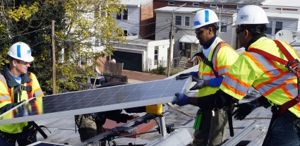 Three WGL volunteers install a solar panel