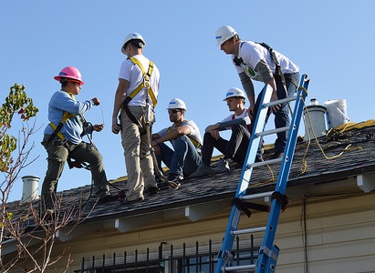 Amaris, in pink hardhat, teaching volunteers about wiring at a recent install.