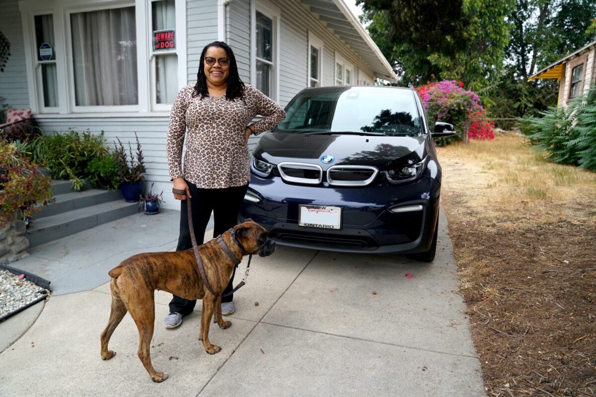 Erica Williams with her dog, Nala, in front of her EV