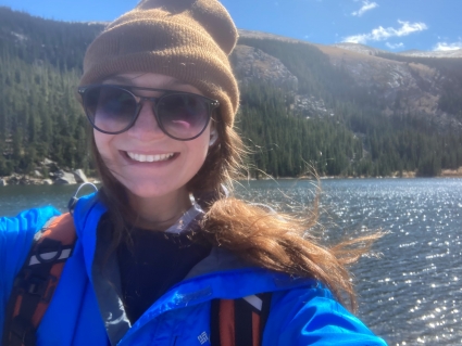 Portrait of Rosa Cleary, smiling in front of a lake