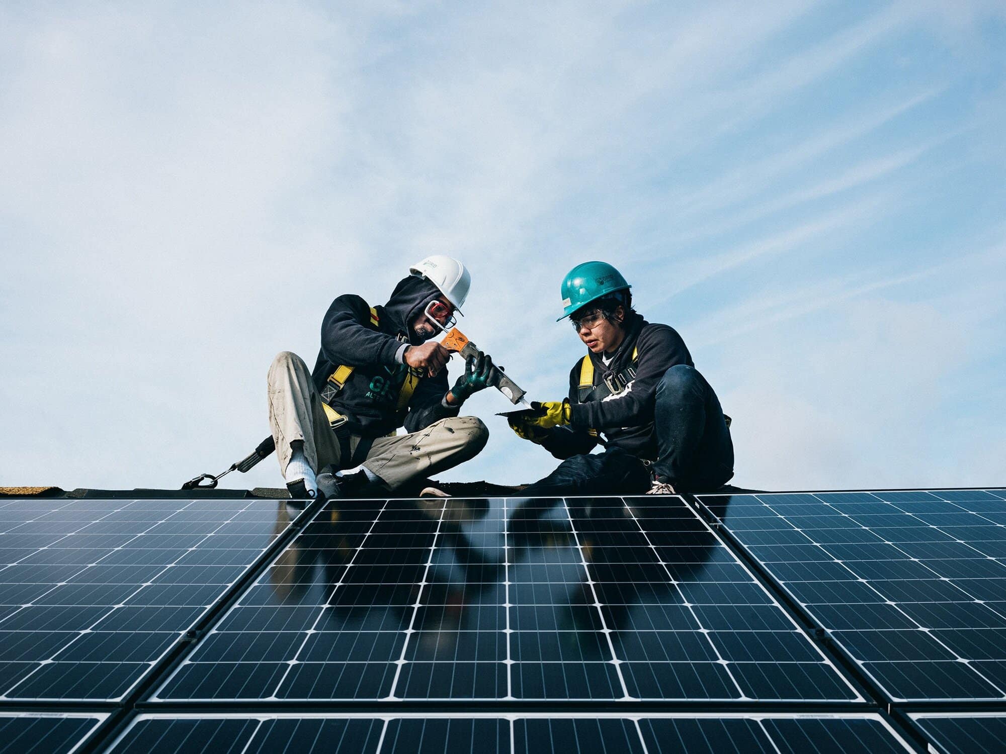 Two installers working on a rooftop solar array.