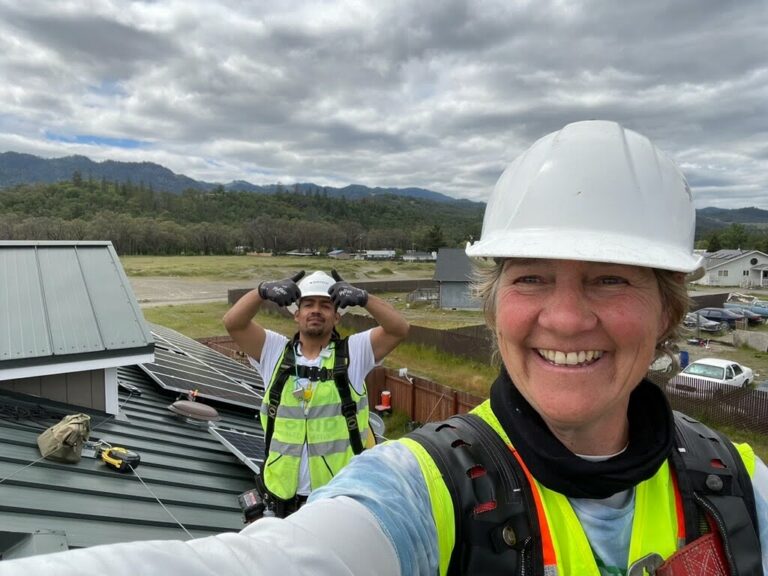 Cora Saxton smiling on the roof with Angelo Bettega behind her