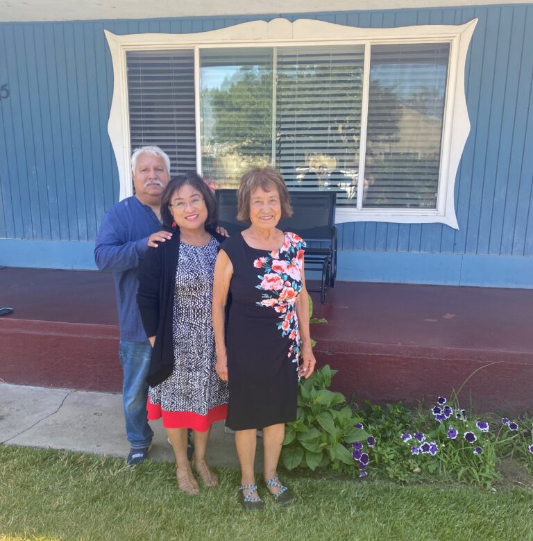 Pauline and her family standing in front of their home.