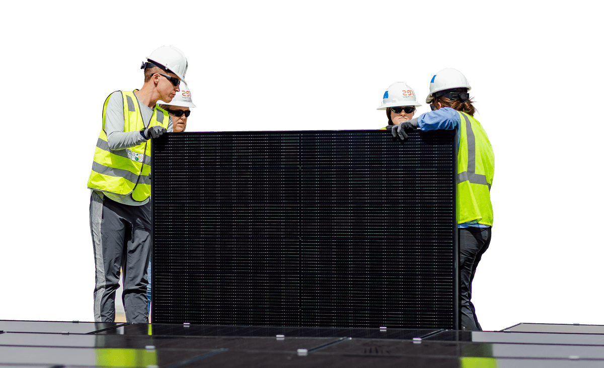 Four workers in safety gear installing a solar panel on a roof