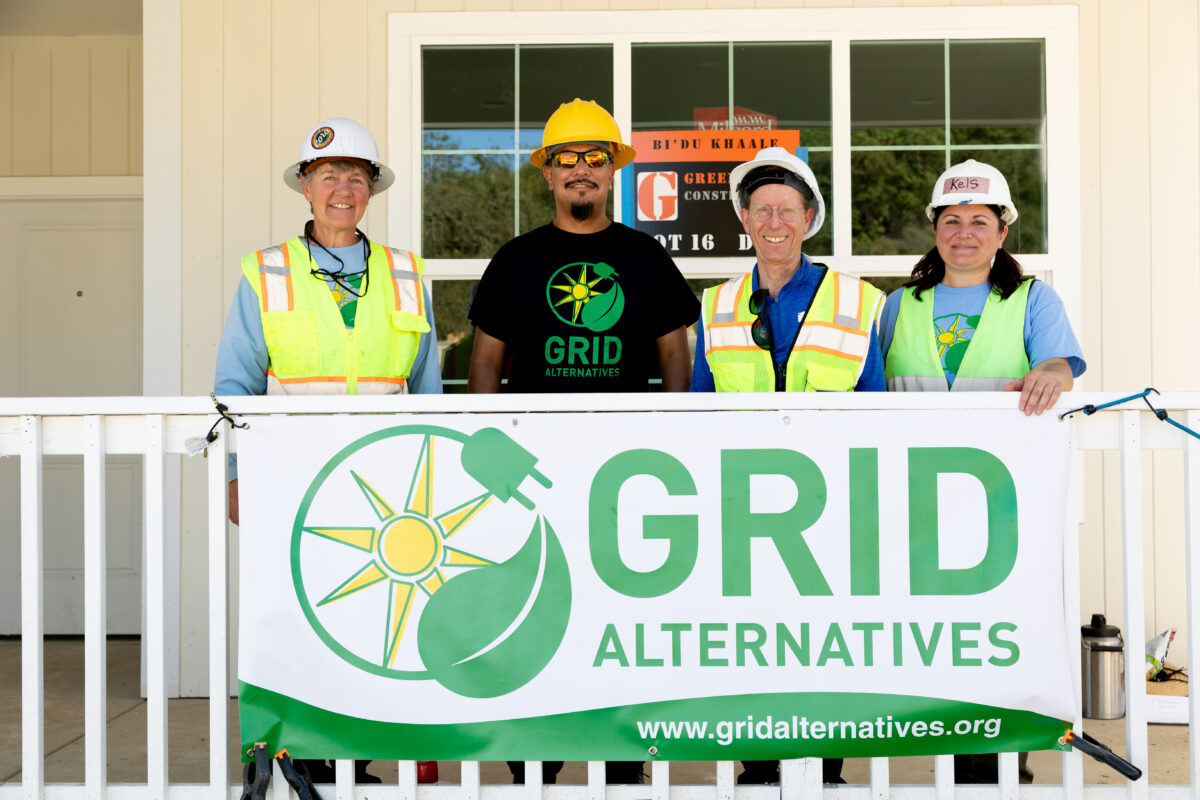 Dry Creek Rancheria Band of Pomo Indians member at center surrounded by GRID Alternatives North Coast team members, Cora Saxton, regional director and Kelsey Radmilovich, outreach manager