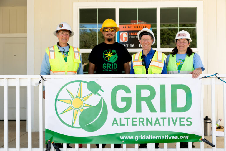 Dry Creek Rancheria Band of Pomo Indians member at center surrounded by GRID Alternatives North Coast team members, Cora Saxton, regional director and Kelsey Radmilovich, outreach manager