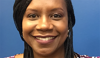 Smiling woman with braided hair against a blue background