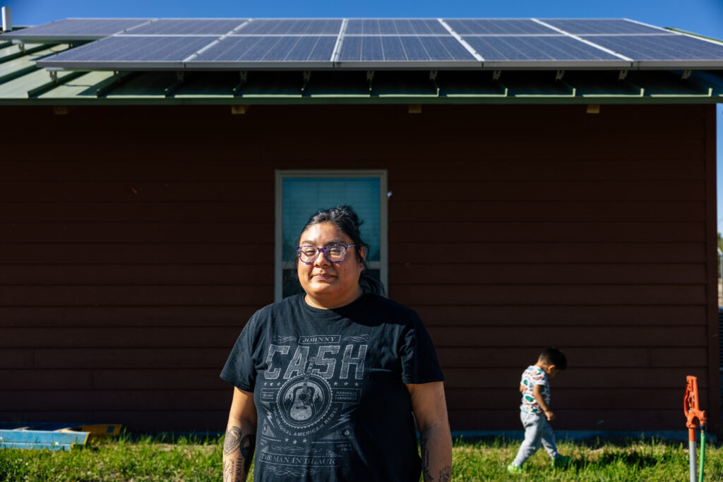 Woman standing in front of her home with rooftop solar