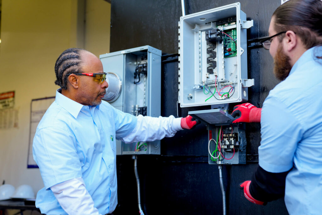 Two people at utility box working