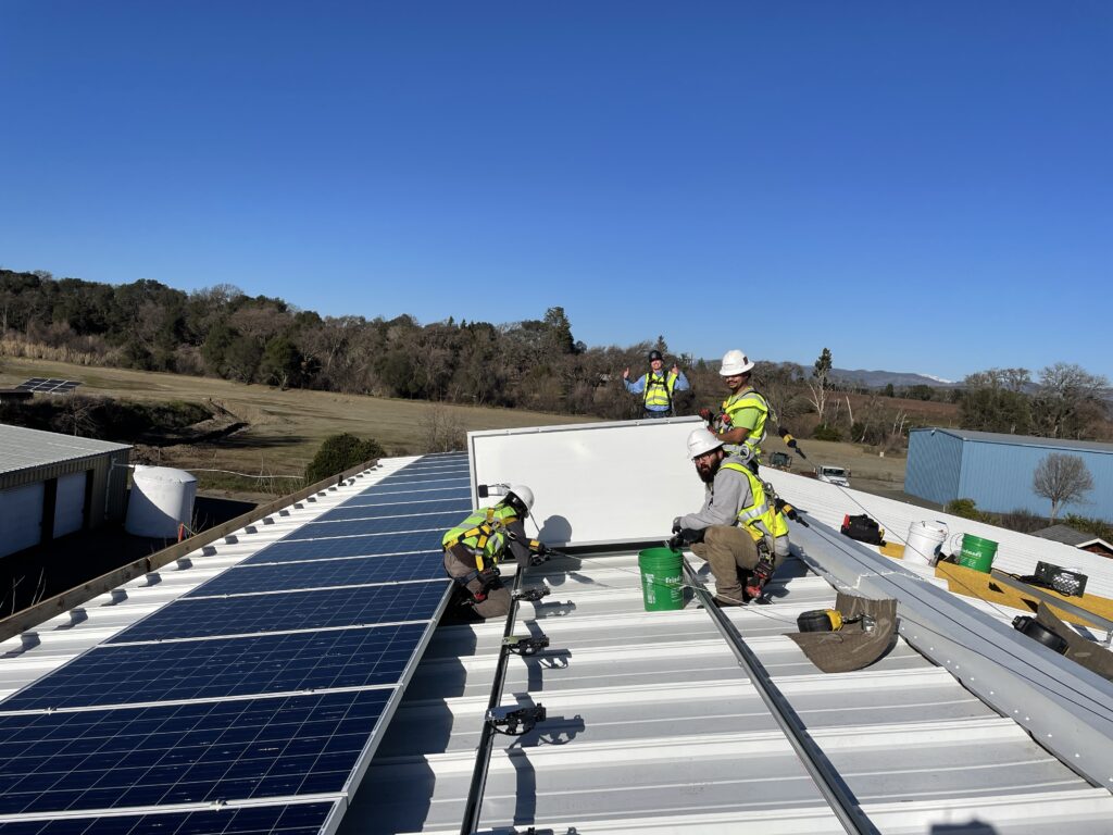 GRID Alternatives Bay Area's North Coast Office Solar Installation Supervisor with Pinoville Pomo Nation Members at an installation of a photovoltaic system in the Nation's community gym