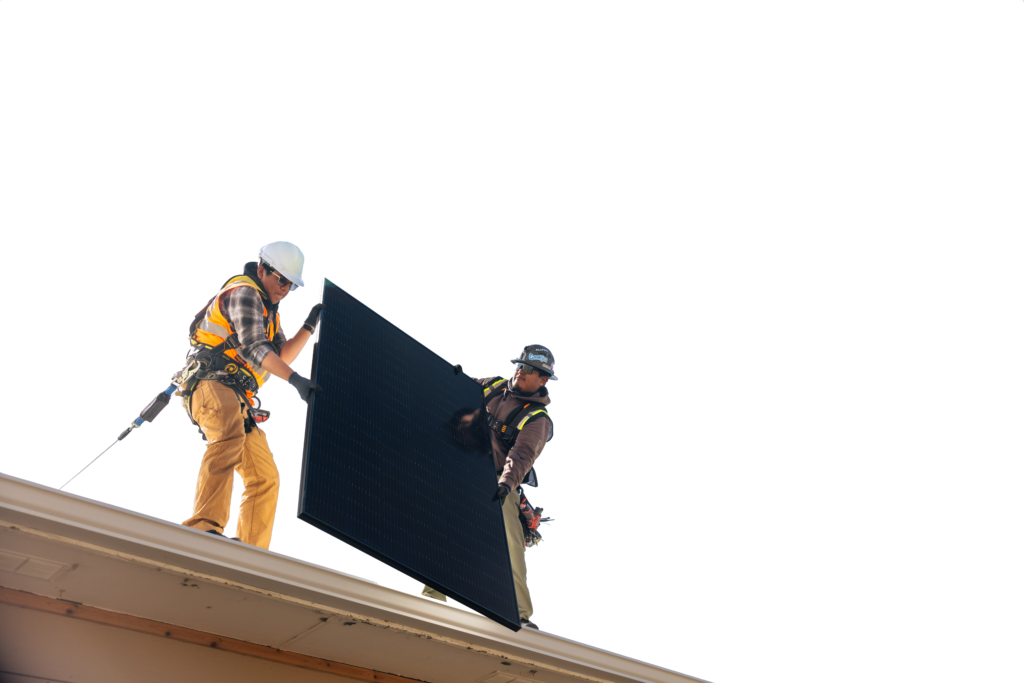 two people holding solar panels on roof